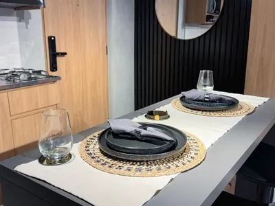 a table with two black plates and glasses on it at Reposso Studio Poblado in Medellín