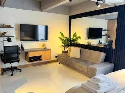 a living room with a couch and a flat screen tv at Reposso Studio Poblado in Medellín