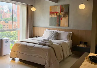 a bedroom with a bed with towels on it at Reposso Studio Poblado in Medellín