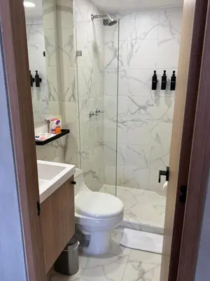 a bathroom with a toilet and a glass shower at Reposso Studio Poblado in Medellín