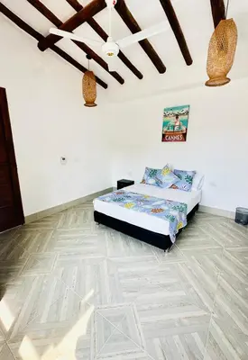 a bedroom with a bed and a wooden floor at Villa Paulina in Honda