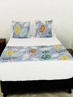 a bed with blue and white sheets and pillows at Villa Paulina in Honda