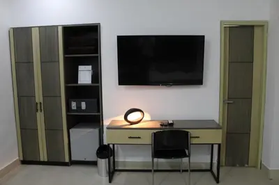 a desk with a computer and a tv on a wall at Hotel Merlott Lleras in Medellín