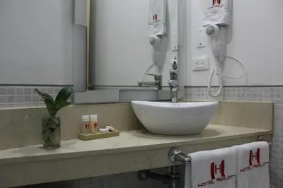 a bathroom counter with a sink and a mirror at Hotel Merlott Lleras in Medellín