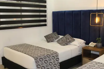 a bedroom with a bed with two pillows and a phone at Hotel Merlott Lleras in Medellín