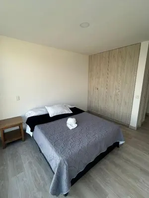 a bedroom with a bed and a wooden floor at Amplio y Suntuoso - estrato 6 in Manizales