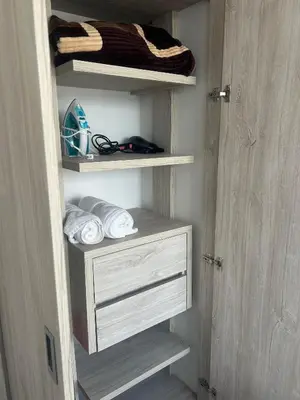 a closet with white drawers and towels in it at Amplio y Suntuoso - estrato 6 in Manizales