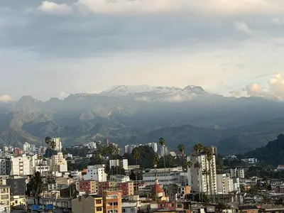a city with a snow covered mountain in the background at Amplio y Suntuoso - estrato 6 in Manizales