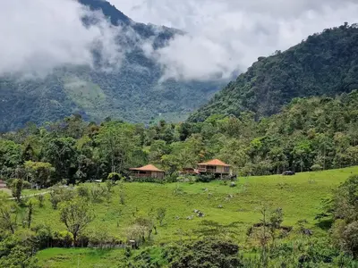 a green field with houses and a mountain at My Paradise Tamesis in Támesis