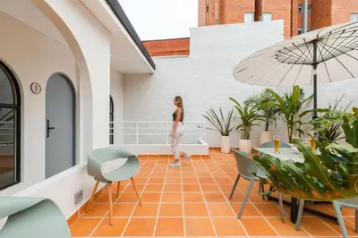 a woman standing on the balcony of a building at Casa Fiora Laureles in Medellín