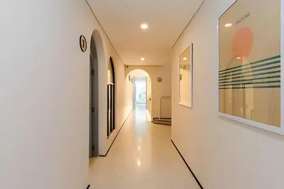 a hallway of a house with white walls and art on the walls at Casa Fiora Laureles in Medellín