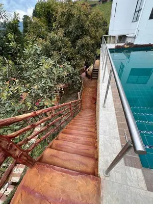 a staircase leading to a swimming pool next to a house at Hotel Golden Hills Manizales in Manizales
