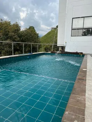 a swimming pool with blue water in front of a building at Hotel Golden Hills Manizales in Manizales