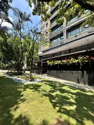 a park with a building with plants and trees at Hotel Living 35 Suites Piso 8 Vip in Medellín
