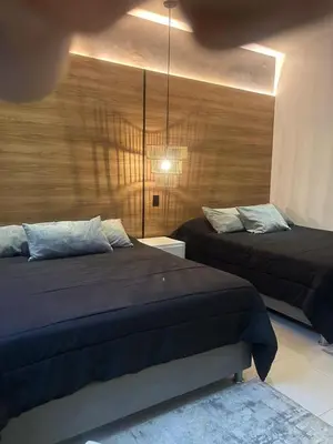a bedroom with two beds and a wooden wall at Dharma Hotel Boutique Spa in San Jerónimo