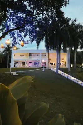 a large white building with palm trees in front of it at Dharma Hotel Boutique Spa in San Jerónimo