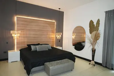 a bedroom with a bed and a chair and a mirror at Dharma Hotel Boutique Spa in San Jerónimo
