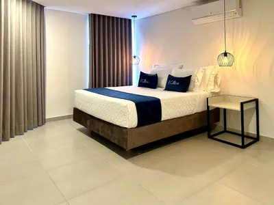 a bedroom with a bed and a side table at Hotel ECO 44 in Medellín