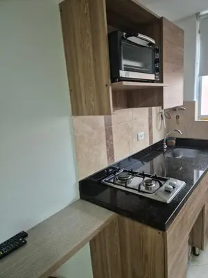 a kitchen with a stove and a microwave at ApartaLoft 12, NevadaLofts Sabaneta in Sabaneta