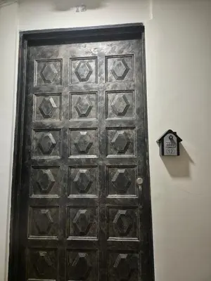 an old wooden door with a clock on a wall at ApartaLoft 12, NevadaLofts Sabaneta in Sabaneta