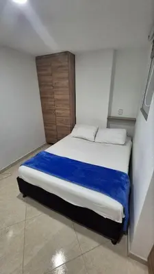 a bedroom with a large bed with a blue blanket at ApartaLoft 13, NevadaLofts Sabaneta in Sabaneta