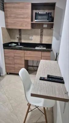 a wooden table with a white chair and a sink at ApartaLoft 13, NevadaLofts Sabaneta in Sabaneta