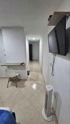 a living room with a flat screen tv on the wall at ApartaLoft 13, NevadaLofts Sabaneta in Sabaneta