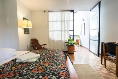 a bedroom with a bed and a desk and a window at Colonial Villa in Laureles, Unique&Special House in Medellín