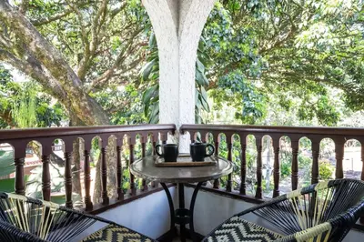 a table and chairs on a balcony with trees at Colonial Villa in Laureles, Unique&Special House in Medellín