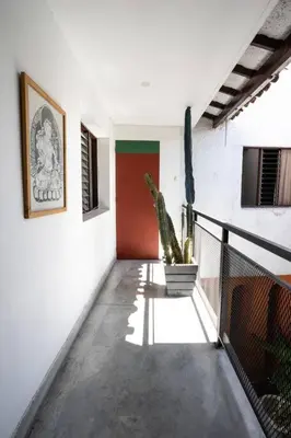a hallway with a potted plant and a red door at Colonial Villa in Laureles, Unique&Special House in Medellín