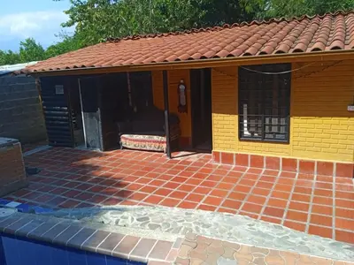 a house with a brick patio with a yellow at Finca Santa fe de Antioquia in Sopetran