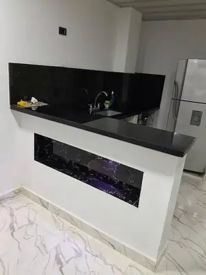 a kitchen with a black counter and a sink at Parcela - Casa del árbol in Doradal