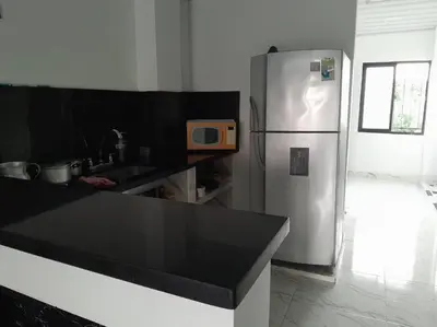 a kitchen with a stainless steel refrigerator with a microwave at Parcela - Casa del árbol in Doradal