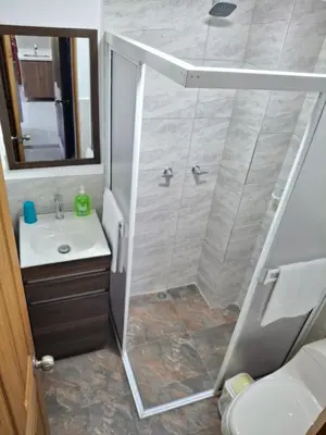 a bathroom with a shower and a sink at Acogedor Apartamento de 3 dormitorios con baños privados - Guatapé Antioquia in Guatapé