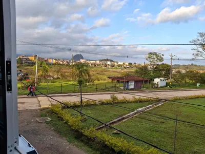 a person walking down a street next to a field at Acogedor Apartamento de 3 dormitorios con baños privados - Guatapé Antioquia in Guatapé