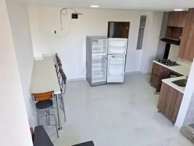 a kitchen with a refrigerator and a counter top at Acogedor Apartamento de 3 dormitorios con baños privados - Guatapé Antioquia in Guatapé