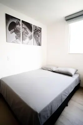 a bedroom with a large bed with three pictures on the wall at Amazing cozy & new flat 3 bedrooms in Medellin best location in Medellín