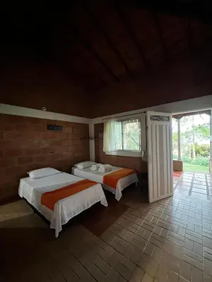 a bedroom with two beds and a large window at Yarumito Finca Hotel l Cabaña Girasol in Barbosa