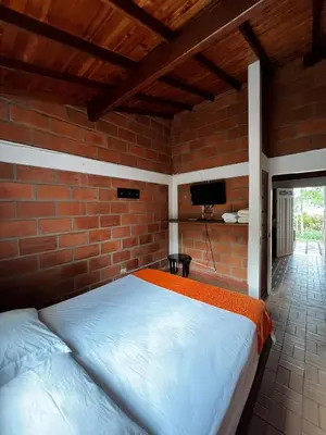 a bedroom with a bed in a brick wall at Yarumito Finca Hotel l Cabaña Girasol in Barbosa