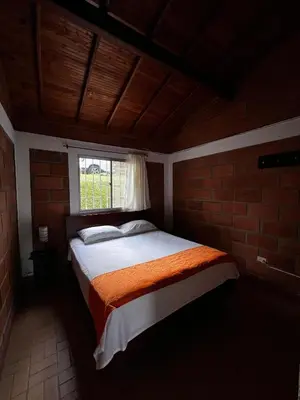 a bedroom with a bed in a brick wall at Yarumito Finca Hotel l Cabaña Girasol in Barbosa