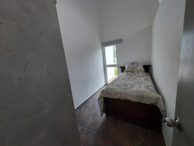 a small bedroom with a bed and a window at Finca Ecológica Sopetran in Sopetran