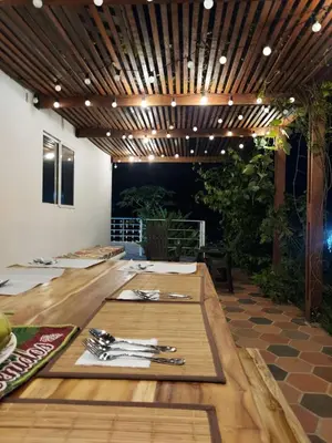 a dining room with a wooden table with utensils at Finca Ecológica Sopetran in Sopetran