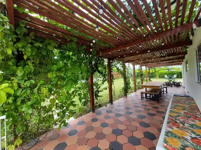 a patio with a wooden pergola with a table and benches at Finca Ecológica Sopetran in Sopetran