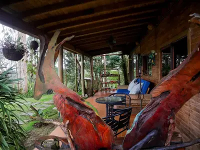 a porch of a house with a table and a tree at Refugio Santa Elena in Santa Elena