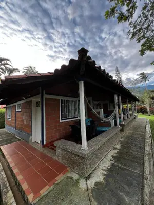 a small red brick house with a roof at Yarumito Finca Hotel Cabaña Narciso in Barbosa