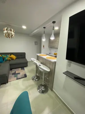 a living room with a couch and a kitchen with a bar at Apartamento Resort Rionegro in Rionegro