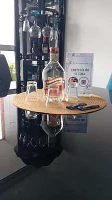 a table with a bottle and two glasses on it at Apartamento Resort Rionegro in Rionegro