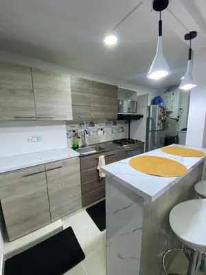 a kitchen with wooden cabinets and a white counter top at Apartamento Resort Rionegro in Rionegro