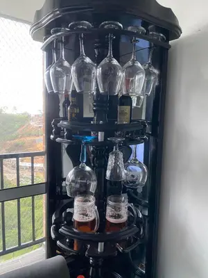 a wine rack filled with wine glasses in front of a window at Apartamento Resort Rionegro in Rionegro