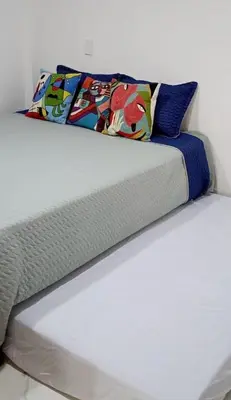 a white bed with two pillows on top of it at 1Cálido y Amarillo in Jericó